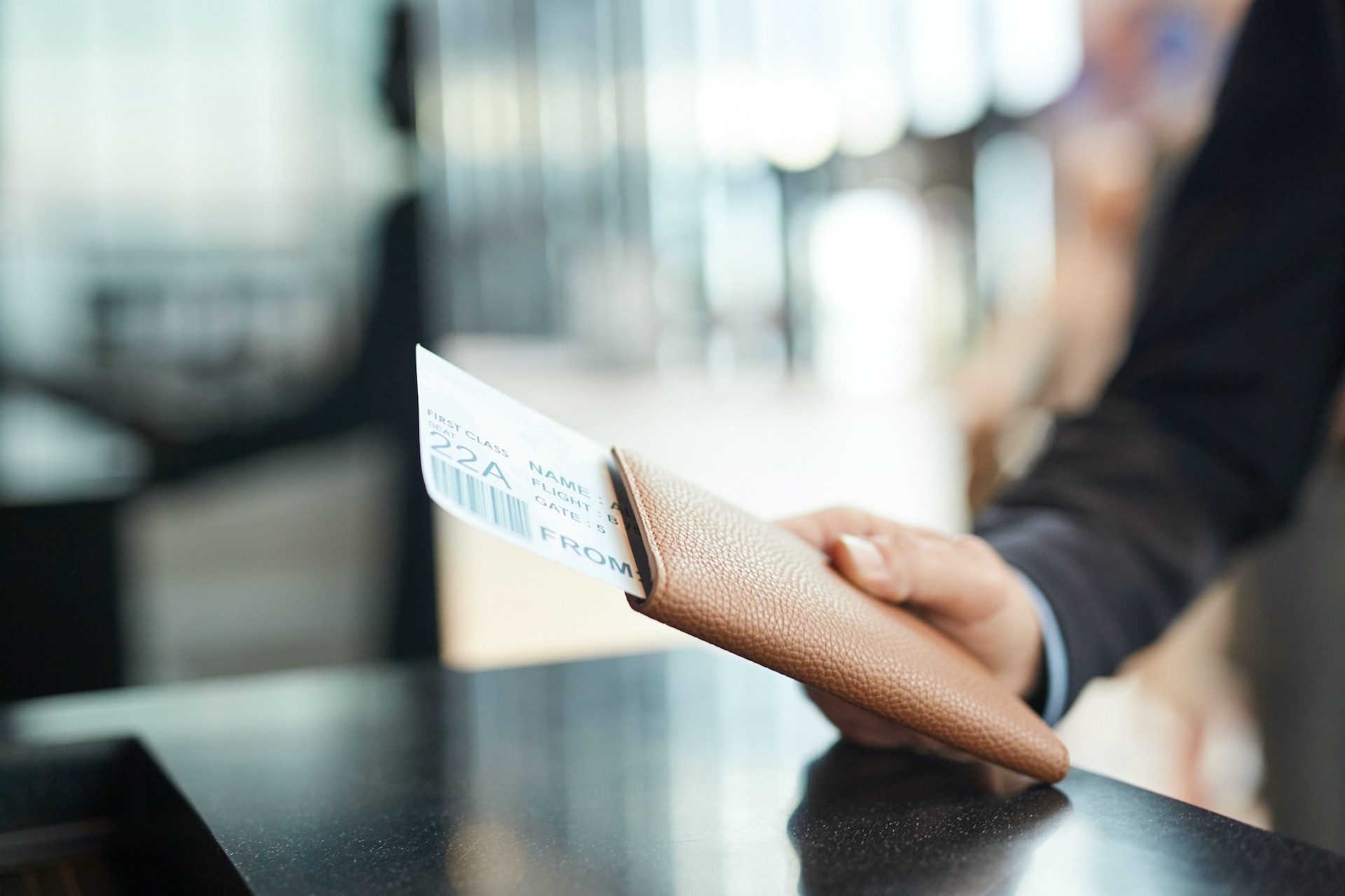 Ein Mann, der am Flughafen sein Flugticket beim Check-In nach vorne hält